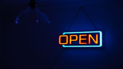 Picture of an illuminated sign that says open.