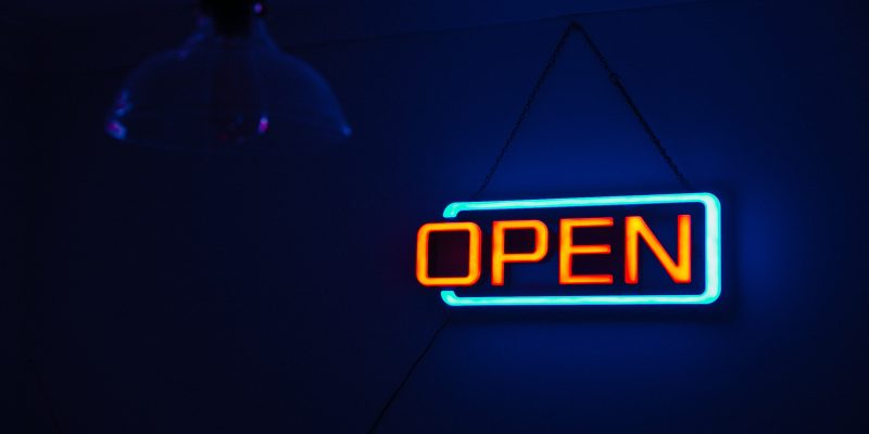 Picture of an illuminated sign that says open.
